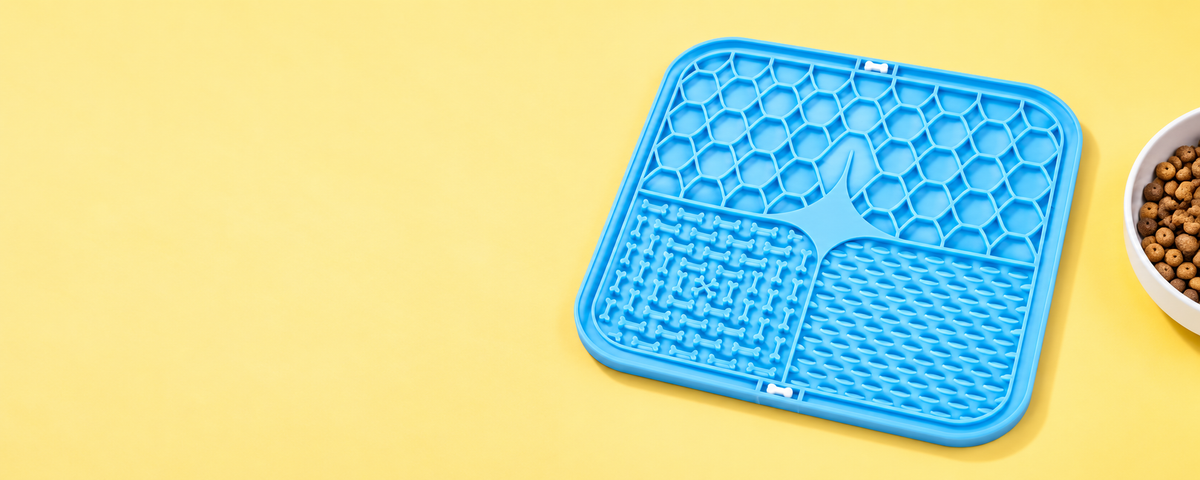 Product styling illustration of the blue textured feeding mat on a yellow surface